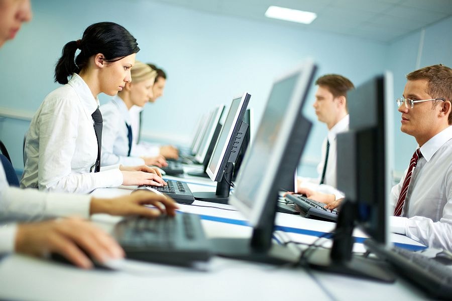 Office with white collar workers working on computers
