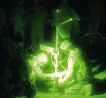 Żołnierze nawiązują połączenie satelitarne w warunkach bojowych.