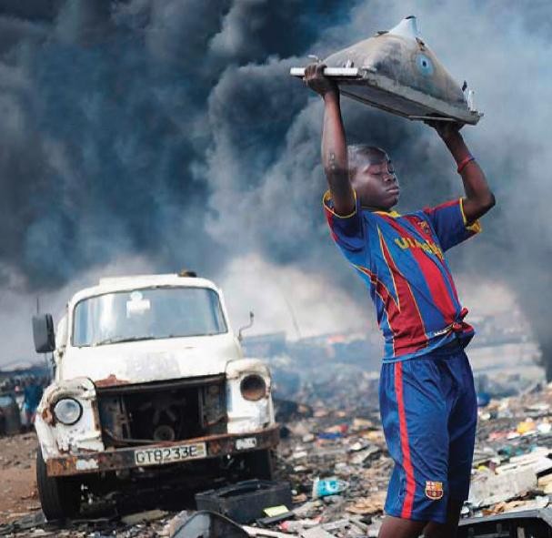 Zatruci ludzie, skażona ziemia. Chłopiec na hałdzie śmieci w stolicy Ghany (Akrze) rozbija zużyty telewizor.