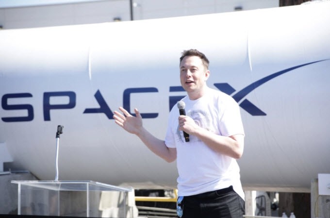 Elon Musk na tle tuby Hyperloop