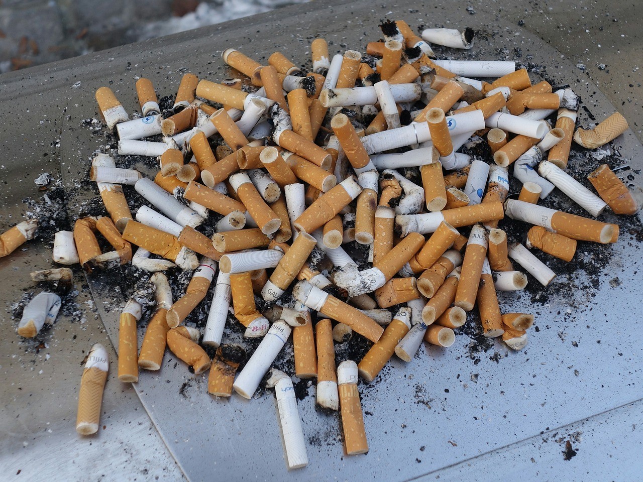 Stos niedopałków po papierosach
